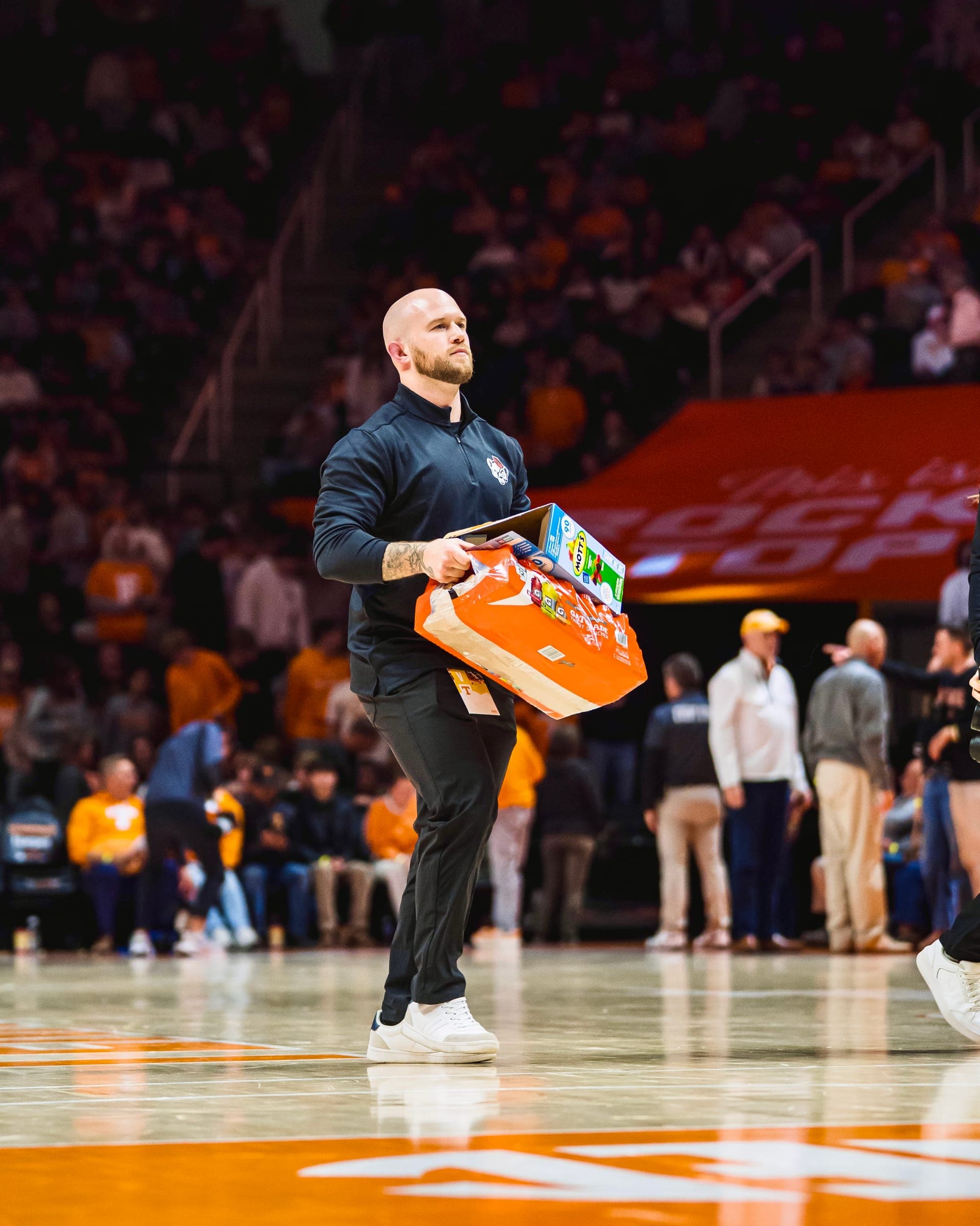 Colin DeClark carrying team drinks across the court before a game