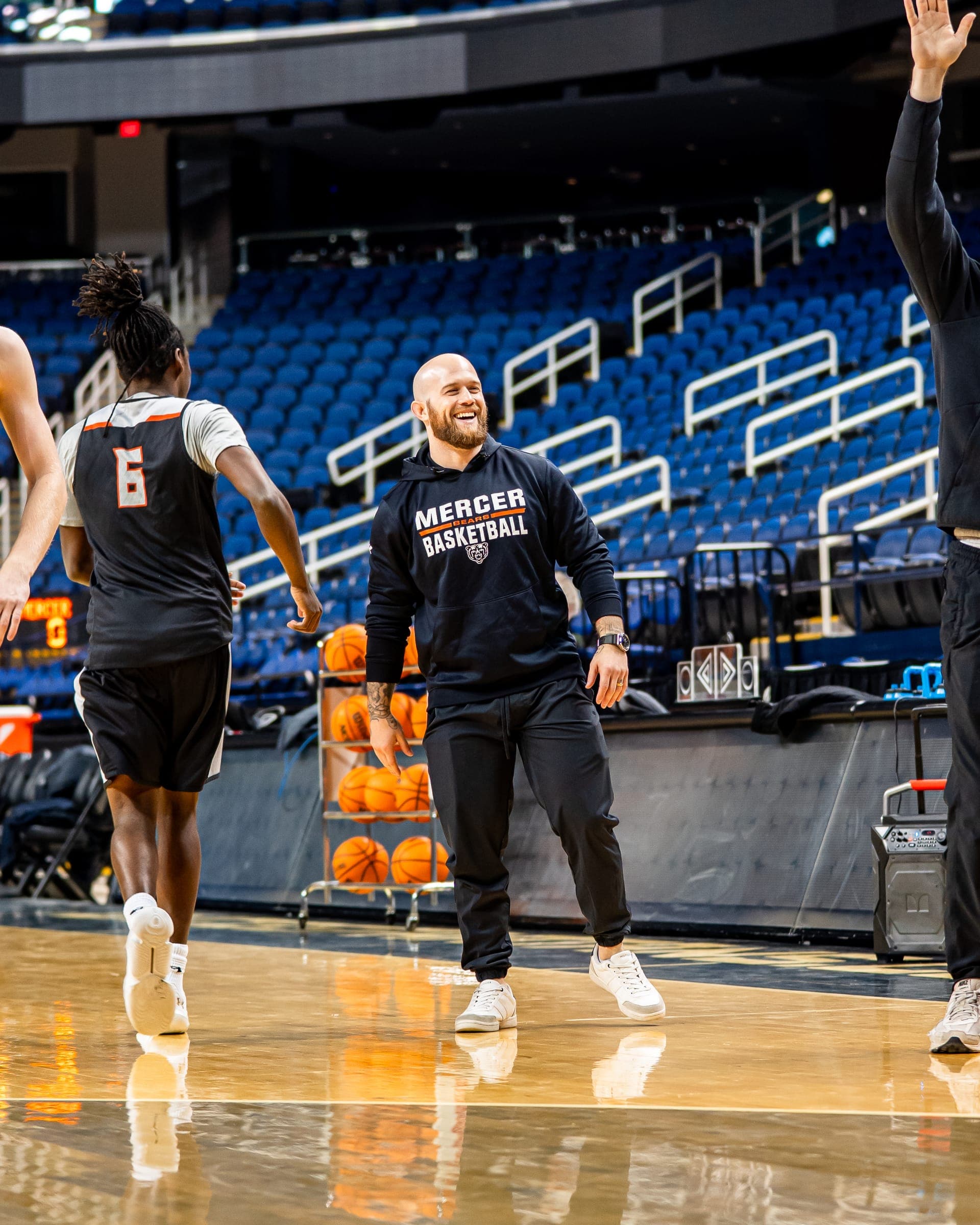Colin DeClark high-fiving a player during a team practice in an arena